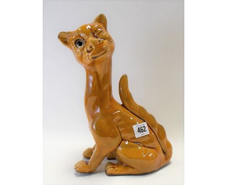 Watcombe Torquay pottery model of a stylised seated winking cat with glass inset eye, stamp mark to the base, height 29cm.