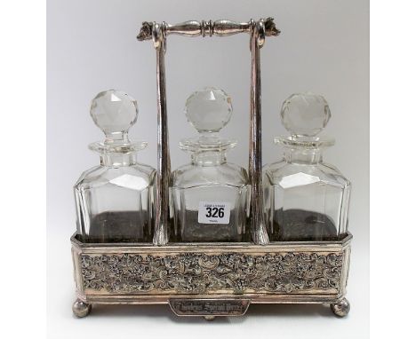 Silver plated three section decanter stand, the handle with cattle head terminals, the rectangular stand embossed with fruiti