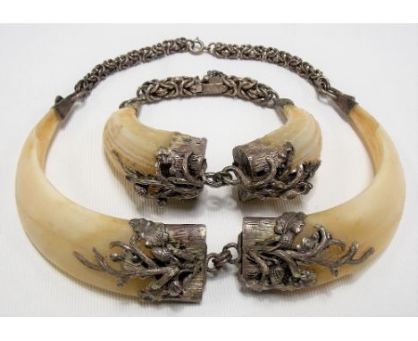 White metal mounted boar's tusk necklace and matching bangle, the terminals applied with acorns and leaves and with a fancy l
