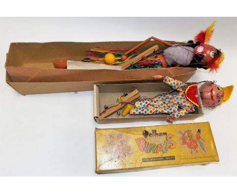 Two boxed Pelham puppets, one a Hawaiian dancer, the other a standard clown puppet.