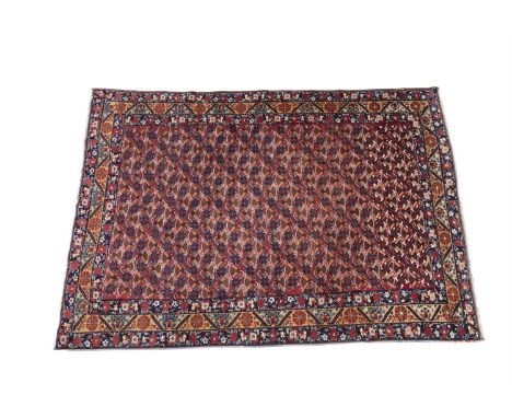 A PERSIAN MOUD RUG, the central rectangular field woven profusely  with interlocking flowers in blue, orange, yellow, red and