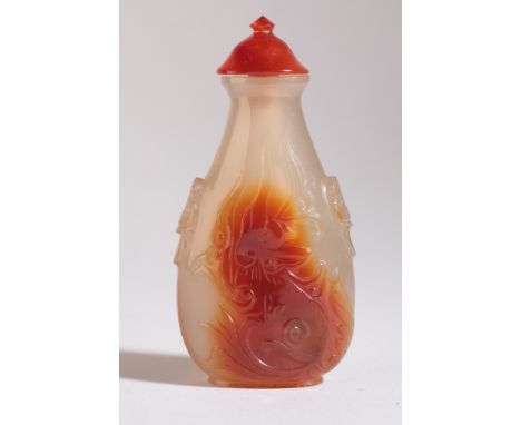A CHINESE AGATE SNUFF BOTTLE 19th century, both sides finely carved with archaic dragons, mask and ring handles to the should