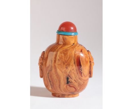 A CHINESE ROOT AMBER SNUFF BOTTLE 18th/19th century, carved to each shoulder with lion mask and suspended loop handles, 6cm h