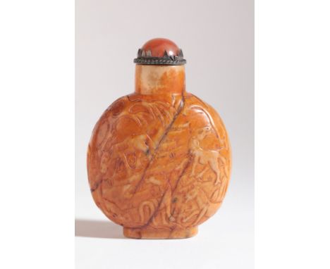 A CHINESE JADE SNUFF BOTTLE probably 19th century, the russet skin carved with horses in a mountainous landscape, standing on