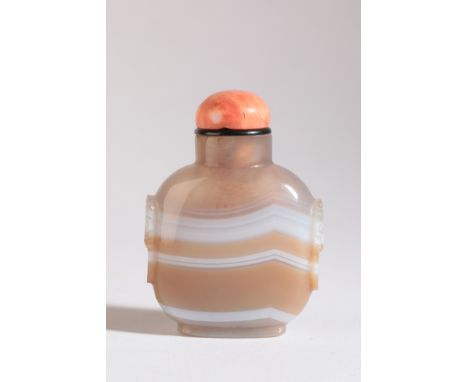 A CHINESE AGATE SNUFF BOTTLE 19th century, the light brown agate with continuous white band, carved mask and ring handles to 