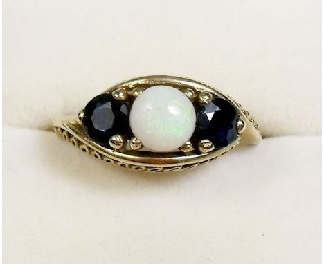 A 9 carat gold ring set opal flanked by two sapphires - size O