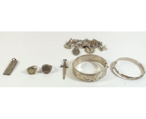 A box of silver jewellery to include two silver bangles, charm bracelet and dagger form pendant