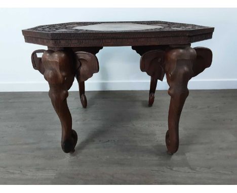 AFRICAN CARVED ROSEWOOD OCCASIONAL TABLE 20TH CENTURY  the octagonal top carved with elephants, on four elephant trunk legs