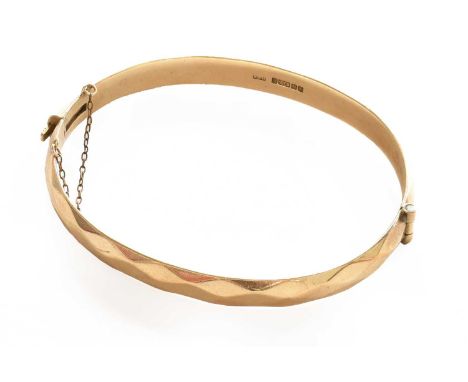 A 9 carat gold hinged bangle, inner measurements 6.2cm by 5.3cmGross weight 23.7 grams.