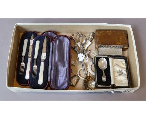 Two silver baby rattles, a silver caddy spoon, a silver tea strainer, two silver bladed mother of pearl handle christening se