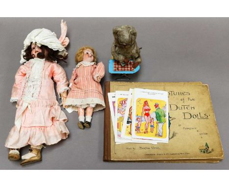 Two German bisque head dolls, a group of novelty seaside postcards, a Japanese clockwork toy, a Florence K Upton book