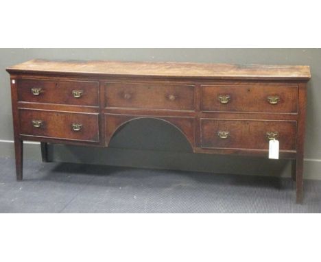 An George III elm kneehole dresser with five drawers surrounding an arch on tappered legs 82 x 205 x 48cm