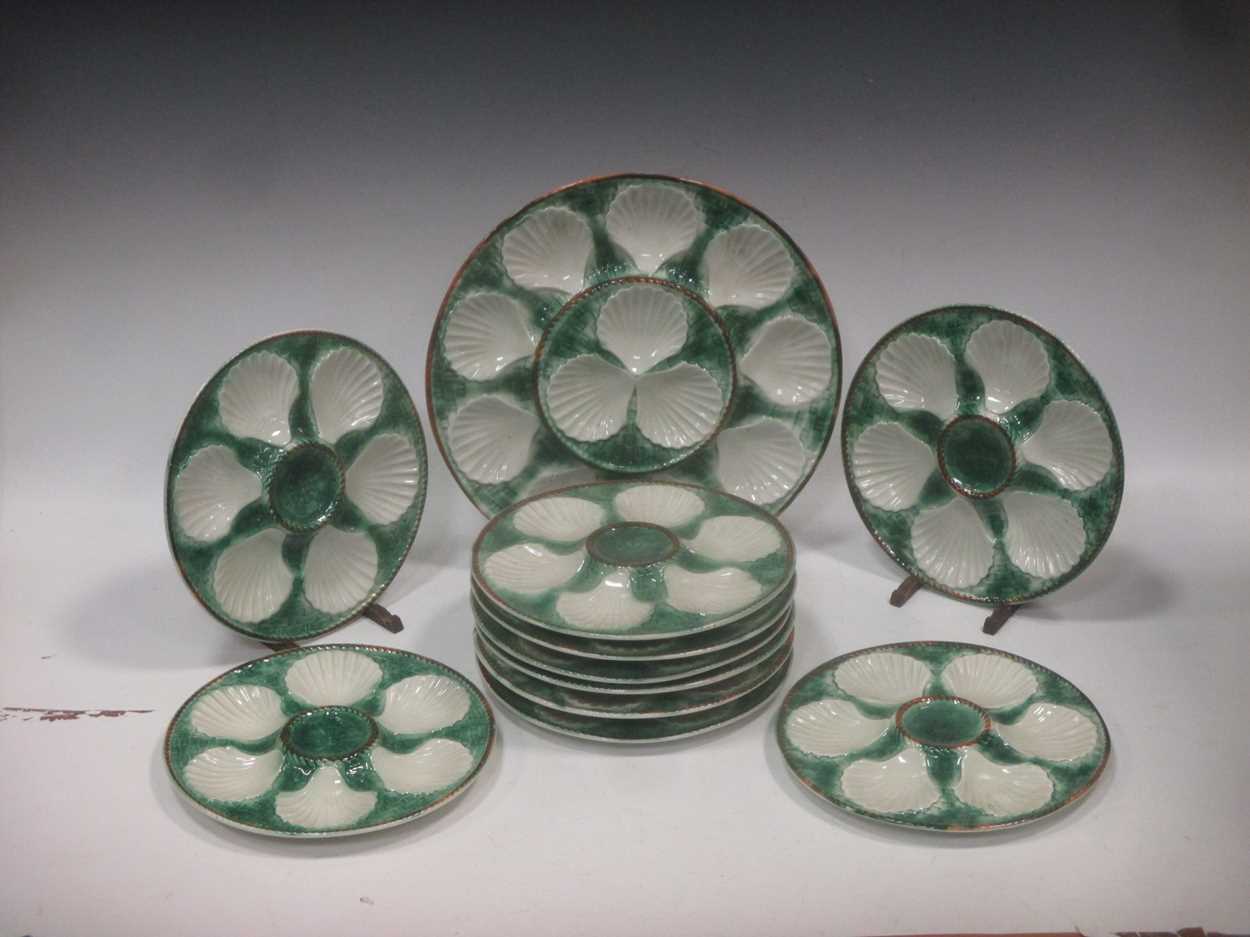 A set of twelve scallop plates, (two broken) together with a serving