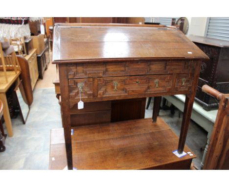 A 17th Century style joined oak clarks slope front desk, the front having a single drawer and decorated with geometric mouldi