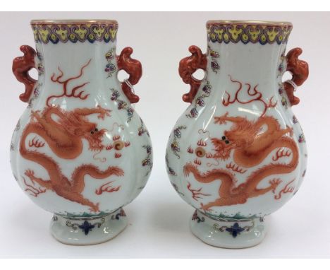 A matched pair of Chinese pollychrome enamel porcelain vases, decorated with an iron red dragon chasing the flaming pearl, wi