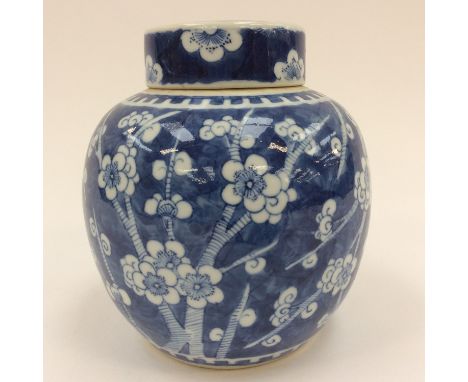 A Chinese 19th Century Kangxi globular shaped blue and white ginger jar and cover with prunus decoration on blue ground, Kang