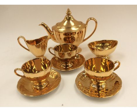 A Royal Winton 'Golden Age' gilt tea service teapot milk and sugar with three cups and saucers