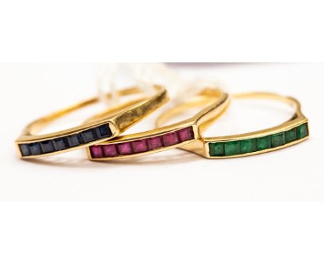 A group of three 14ct matching gold rings, each ring channel set, one set with ruby,  one with emerald and one with sapphire,