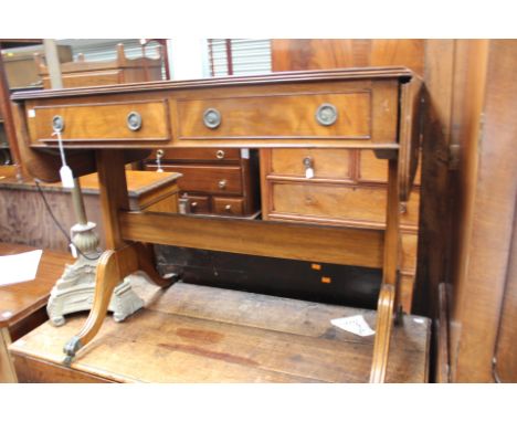 A Regency style mahogany sofa table, fitted with two drawers, raised on sabre legs