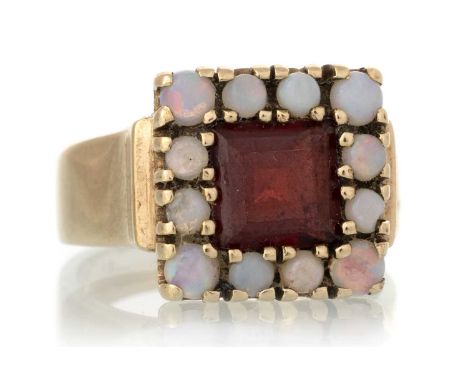 GARNET AND OPAL RING, set with a central garnet within a halo of opals, marked 9CT, size MQty: 7.2gWell worn condition. Opals