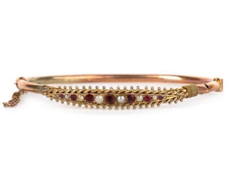 VICTORIAN RUBY AND SEED PEARL BANGLE, set with alternating rubies and pearls, indistinct mark to the claspMost stones have be