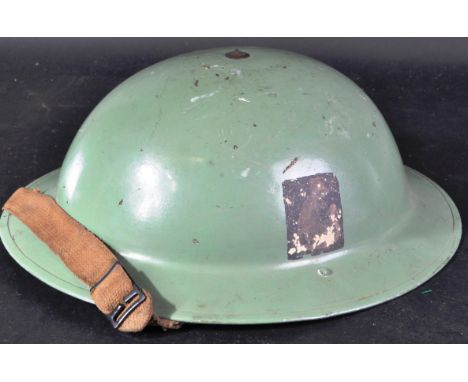 A scarce original WWII Second World War British Army Brodie helmet in typical form, with original green colour scheme and rem