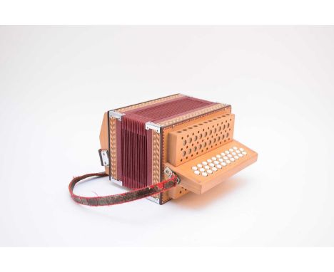 A contemporary three-row diatonic button accordion, with 31 buttons to the right-hand side and two rows of eighteen buttons t