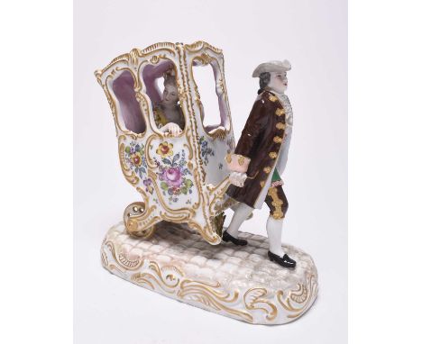 A Paris porcelain model of a footman pulling a lady in a sedan, circa 1880, modelled by Marc Eugene Clauss, underglaze blue c