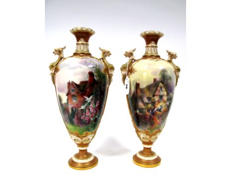 A Pair of Royal Worcester Porcelain Vases and Covers, (finials detached), of two handled extended ovoid form raised on circul