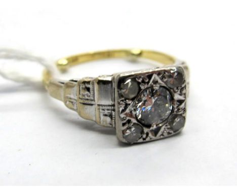 An Art Deco Diamond Set Ring, the high square panel set with graduated old and single cut stones, between textured stepped sh