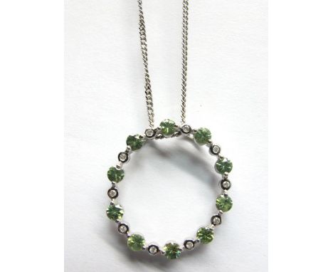 A Peridot and Diamond Set Circlet Pendant, alternately set, stamped "9k", on 9ct white gold chain.  *Ernest Jones Insurance V