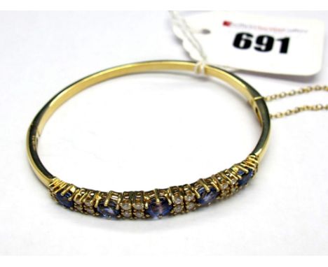 A Modern 18ct Gold Diamond Set Bangle, alternately claw set to the front, hinged to snap clasp.