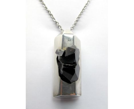 A Hallmarked Silver Pendant, FRN (Nunn), Sheffield 1978, of modernist design, set with quartz specimen, on long chain.