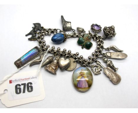 A XIX Century Charm Bracelet, suspending numerous assorted XIX Century and later charm pendants, including butterfly wing pan