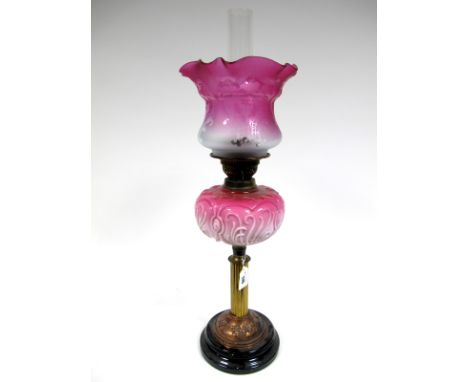 A Late XIX Century Oil Lamp, the brass fluted column with domed Art Nouveau scrolling copper base, opaque pink moulded glass 