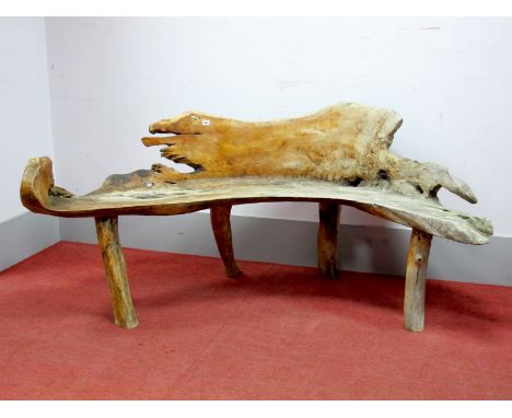 A 'Rustic' Hardwood Wrythen Crescent Garden Seat, formed from the trunk of a tree, supported on four branch feet, 207cm long.