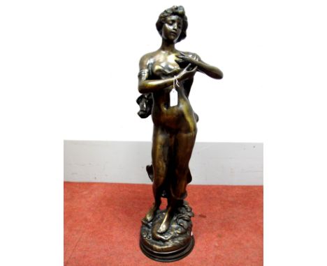 An Early XX Century Bronze Figure of a Classical Maiden, scantily clad, her arms held across her body, on a naturalistic circ