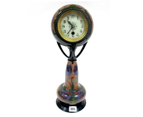 An Art Nouveau Gouda Pottery Cased Mantel Clock, the circular white enamel dial with Arabic numerals, raised on four branch s