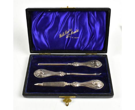 GIBSON &amp; CO LTD; an Edward VII hallmarked silver three piece manicure set, the silver handles with repoussé detail, lengt