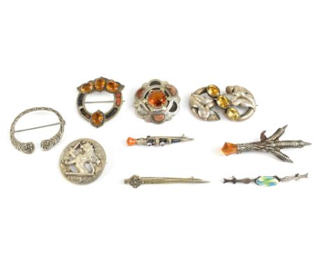 A group of nine Scottish silver brooches, including a Celtic knot, hardstone set pierced example, grouse foot, dirk etc, some