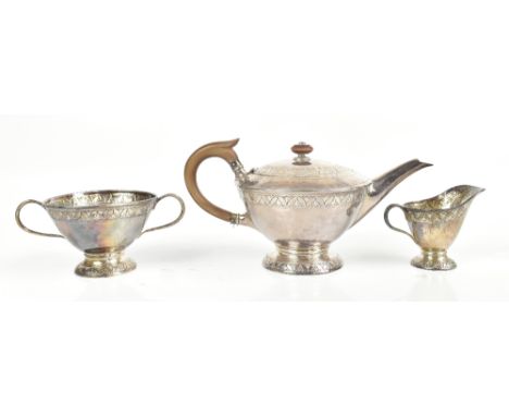 LIBERTY &amp; CO; a George V hallmarked silver three piece tea service, each with planished and embossed stylised floral deco