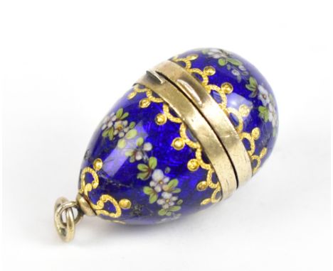 A 19th century Continental white and gilt metal vinaigrette in the form of an egg, with enamelled decoration, floral detail a