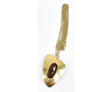 A 1970s abstract yellow metal pendant centred with a smoky quartz and suspended on a fine link chain, length of pendant inclu