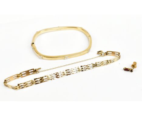 A 9ct yellow gold bangle of rounded rectangular form with simulated screw heads, external measurement 6.5 x 5.5cm, a 9ct yell