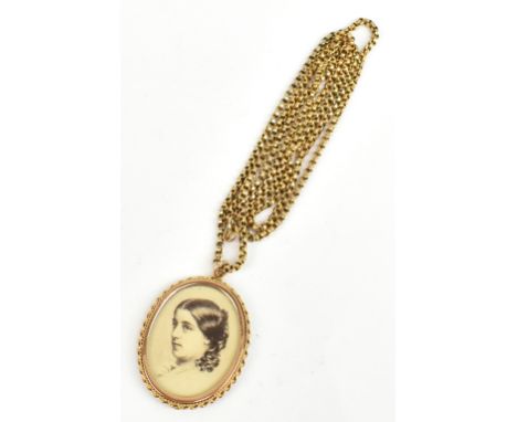 A 9ct yellow gold oval pendant centered with the printed portrait of a young woman and with glass back, length 4.2cm, suspend