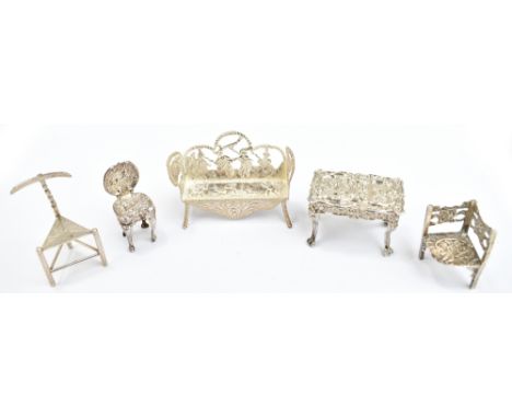 A 19th century Dutch silver miniature garden bench with figural detail to back and sides, pseudo marks to underside, on four 