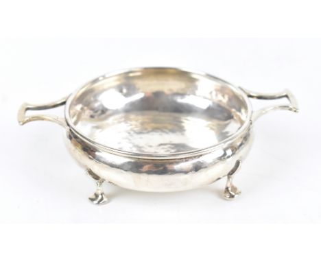 ALBERT EDWARD JONES; a George V hallmarked silver Arts &amp; Crafts twin handled footed bowl with planished detail, Birmingha