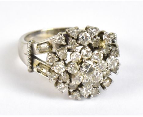 An 18ct white gold cluster ring set with approximately thirty three brilliant cut stones, the largest central stone weighing 