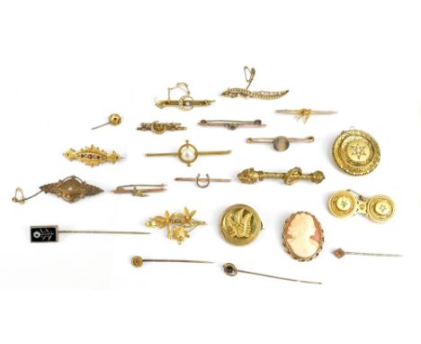 A large group of yellow metal brooches, tie and stick pins including a circular leaf decorated example, twin panelled example