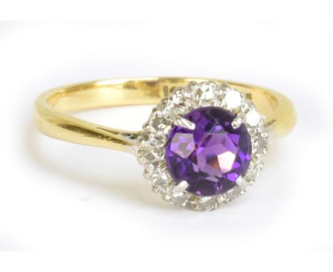 An 18ct yellow gold and platinum tipped diamond and amethyst ring, the central amethyst within a border of twelve diamonds, r